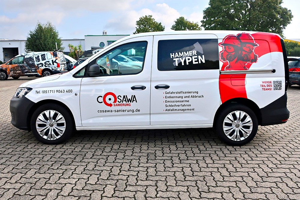 Seitenansicht eines folierten VW Caddy mit "HAMMER TYPEN" Slogan und Leistungsübersicht der Firma COSAWA Sanierung.